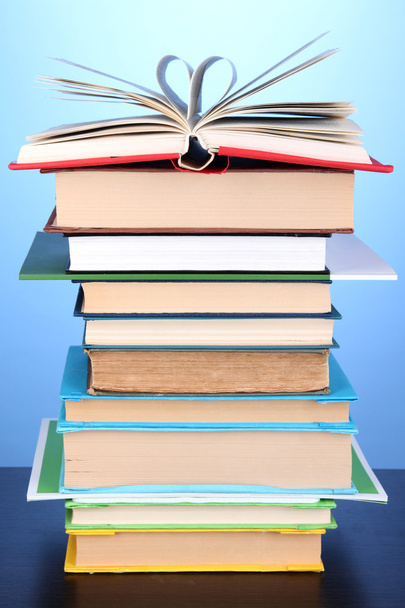 Stack of interesting books and magazines on wooden table on blue background - Foto, Bild