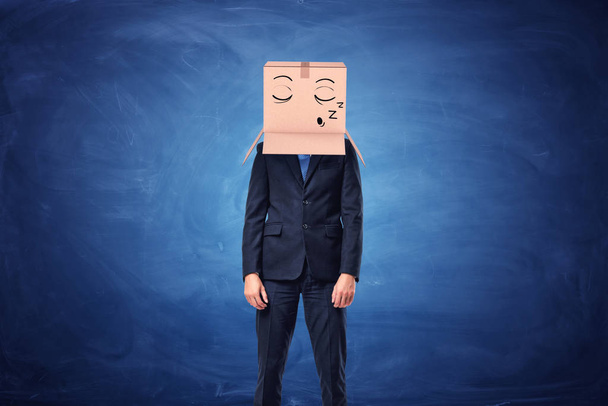 Businessman is wearing cardboard box on head with sleepy face - Foto, afbeelding
