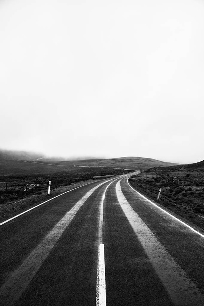 Estrada e montanhas na zona rural da Tasmânia. Preto e branco
 - Foto, Imagem