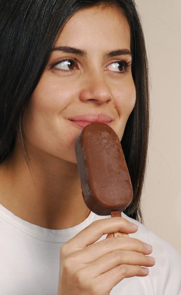 Young woman eating a chocolate ice cream - Fotografie, Obrázek