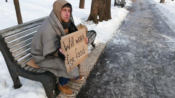  4K.Joven hombre de desempleo en el banco en el parque de la ciudad de invierno. Ningún trabajo es problema
 - Metraje, vídeo