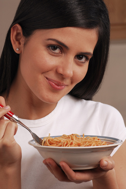 Jovem mulher comendo massa
 - Foto, Imagem