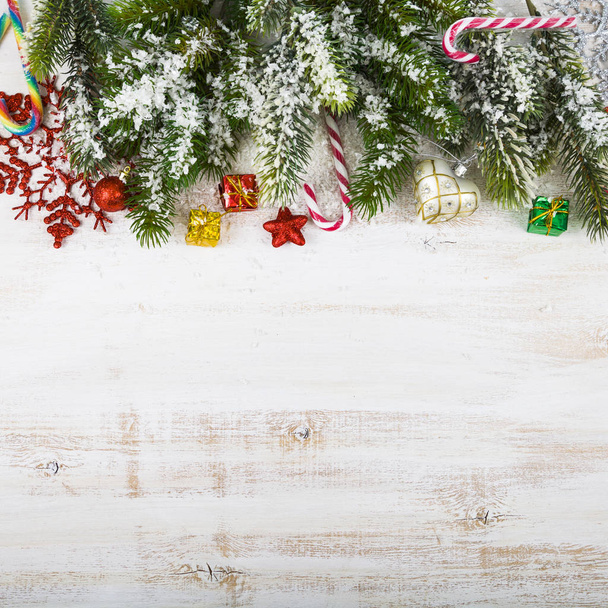 Новорічні прикраси, подарунки та ялинкові гілки на дерев'яному столі
. - Фото, зображення
