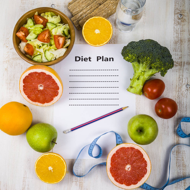 Food and sheet of paper with a diet plan on a  wooden table. Con - Foto, immagini