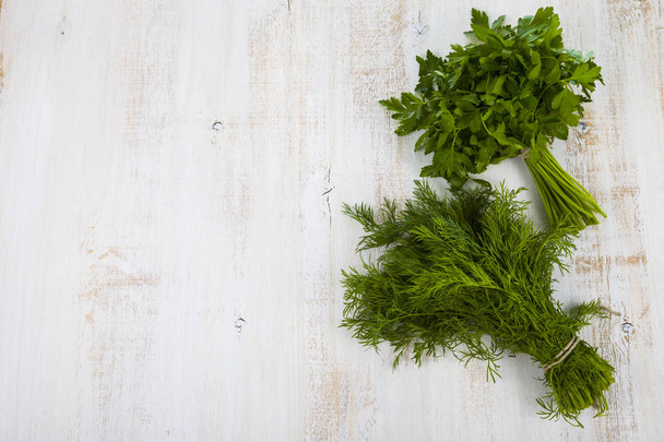 Dill and parsley on a light wooden table. Herbs closeup. - Foto, Imagen