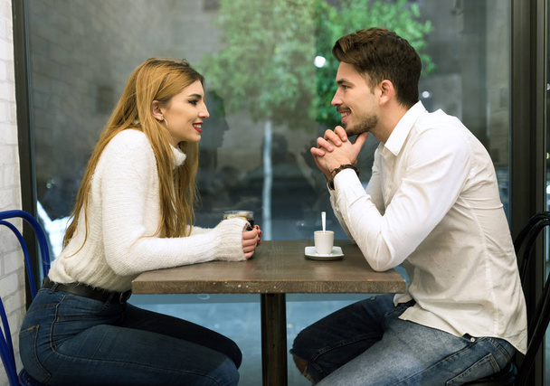 Beautiful young couple in love at a coffee shop. - 写真・画像