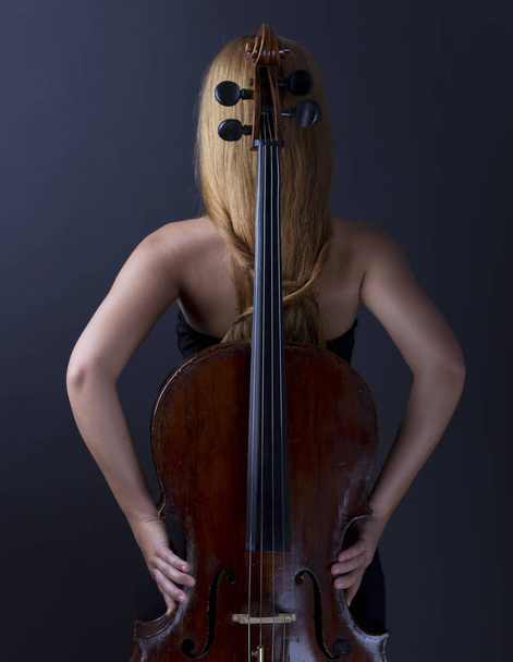 Bella ragazza con un violoncello al buio. Violoncello. Ragazza con lunghi capelli lisci
 - Foto, immagini