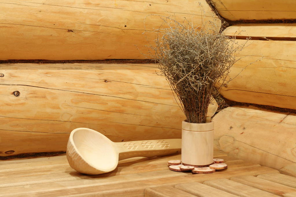 Pincel de sagebrush seco para vapor e uma concha de madeira em um banho russo
. - Foto, Imagem