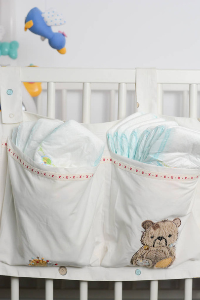 Pile o pila di pannolini nella borsa per bambini appesa al letto
 - Foto, immagini