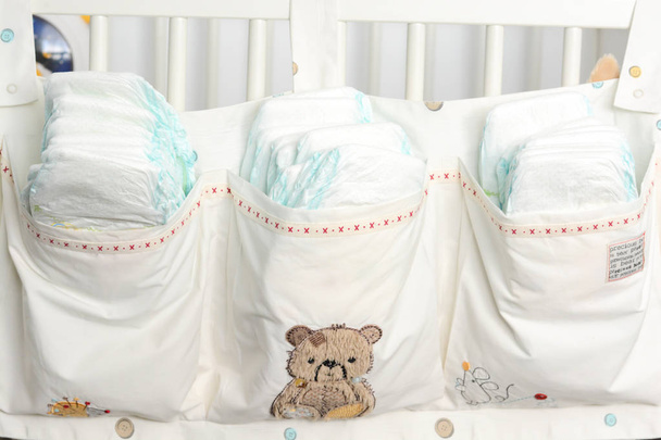 Куча или стопка подгузников в детской кроватке
 - Фото, изображение