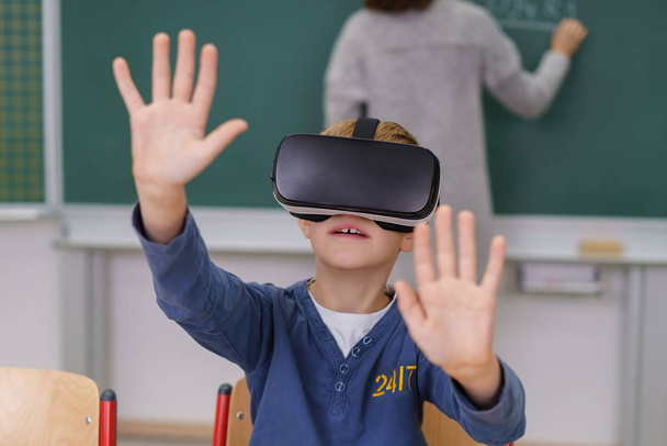 Boy in VR helmet groping invisible wall - Zdjęcie, obraz