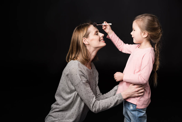 Mother and daughter applying makeup - 写真・画像