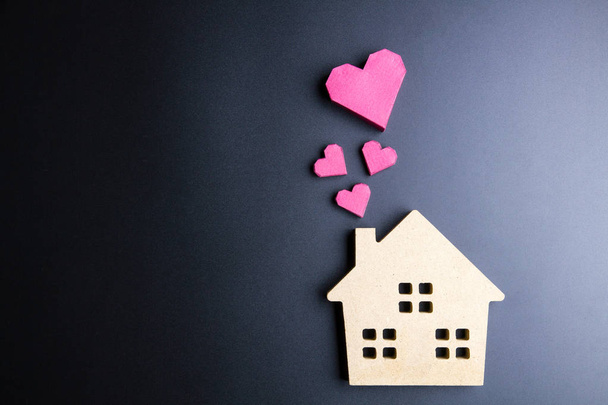Maison en bois jouet et boîte en papier rouge forme de coeur sur backgrou noir
 - Photo, image