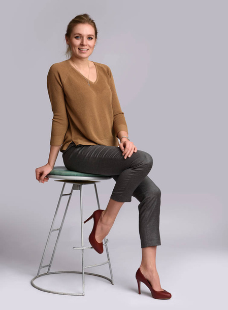 smiling woman sits on chair - 写真・画像