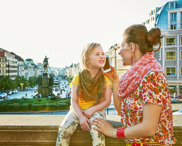 mother and daughter travellers in Prague using smartphone - Foto, imagen