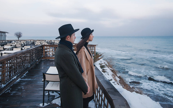 Casal na moda em pé no terraço do mar
 - Foto, Imagem