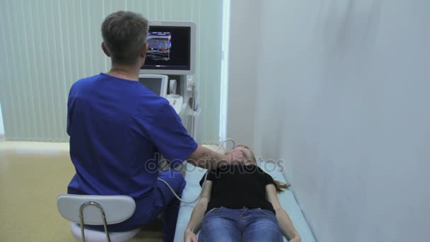 Médico hace ultrasonografía tiroides chica
 - Imágenes, Vídeo