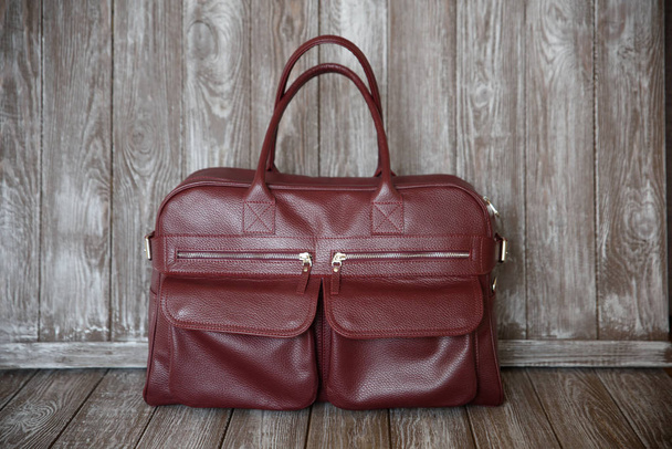red leather bag on brown wooden background. - Fotografie, Obrázek