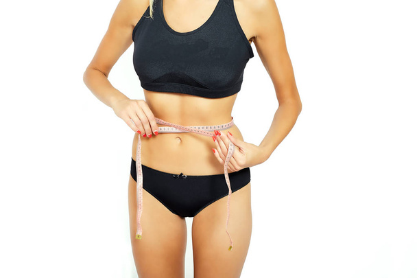 Young attractive woman measuring her hips - Photo, Image