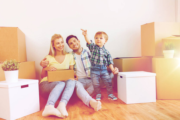 happy family with boxes moving to new home - Foto, Bild