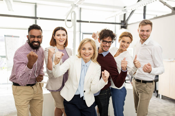 happy business team celebrating victory at office - 写真・画像