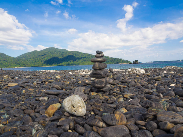 Pedra de equilíbrio na praia mar fundo de montanha, símbolo de pico
 - Foto, Imagem