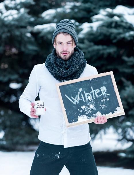 handsome man with cup and blackboard in winter outdoor - Foto, Imagen