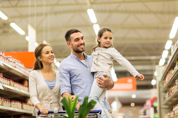 family with food in shopping cart at grocery store - Foto, immagini