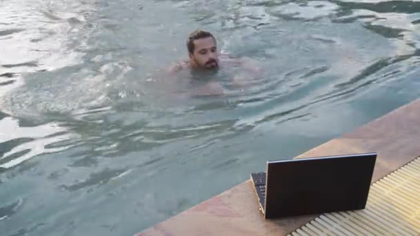 Jovem conversando com laptop por piscina no hotel
 - Filmagem, Vídeo