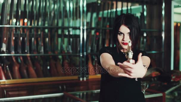 Houkutteleva nainen tähtää aseella
. - Materiaali, video
