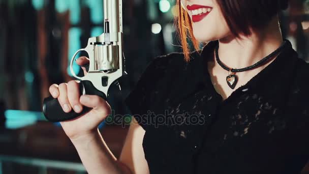 Tyttö, jolla on ase ja joka poseeraa asekaupassa.
. - Materiaali, video