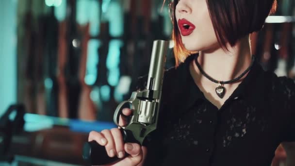 Kırmızı dudaklar ve elinde bir silah ile bir esmer kız portresi. - Video, Çekim