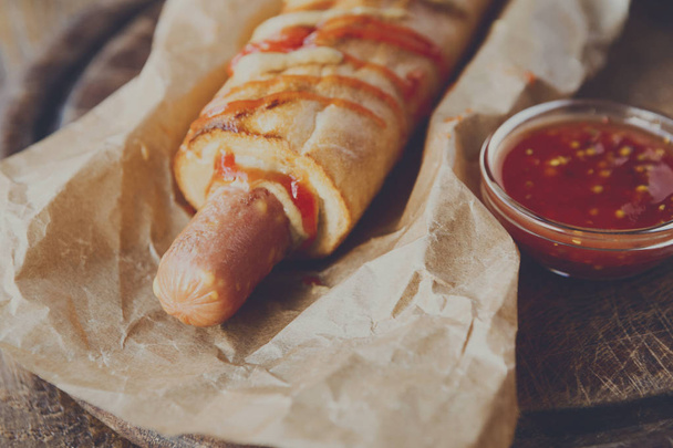 Frans hotdog op ambachtelijke Inpakpapier op hout - Foto, afbeelding