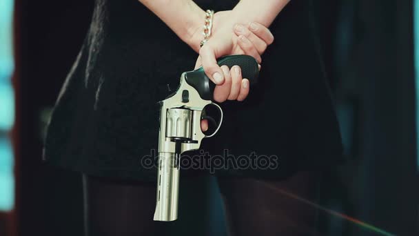 Bir tabanca arkasında tutarak siyah elbiseli genç kız - Video, Çekim