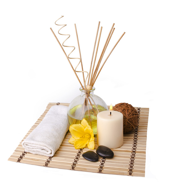 Spa setting with aroma sticks, candle, flower, towel, wooden ball and rocks isolated on white background - Photo, image