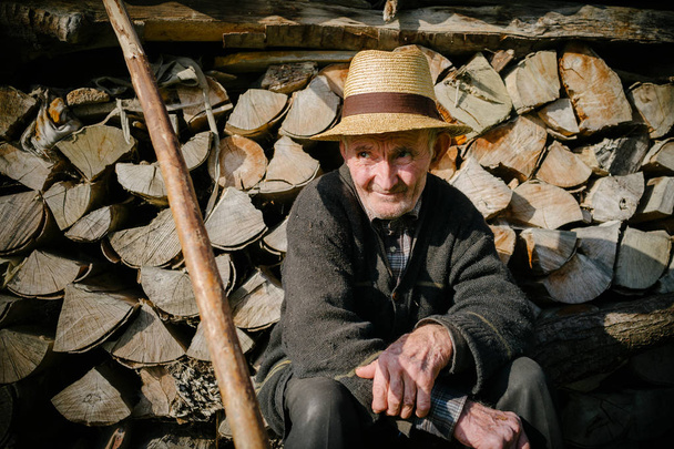 Man in hat sitting near fire woods - Zdjęcie, obraz