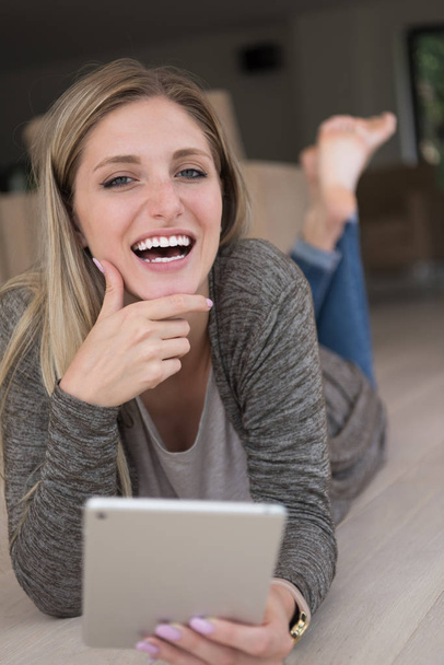 mladá žena používá tabletový počítač na podlaze - Fotografie, Obrázek