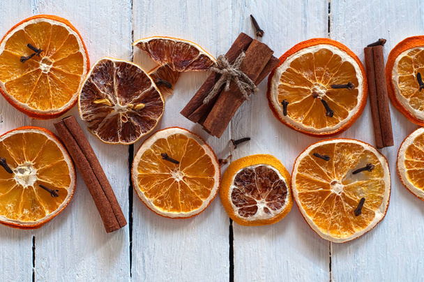 Rodajas secas de naranja y limón con palitos de canela
 - Foto, Imagen
