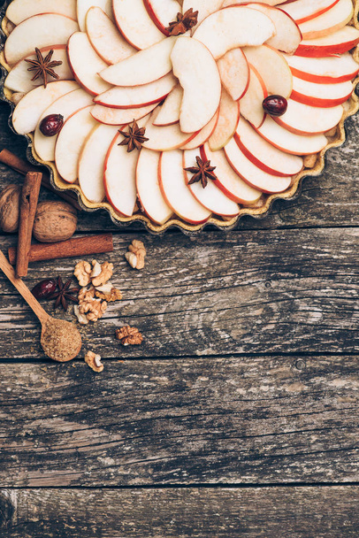 Apple pie tart on rustic wooden background. Ingredients - apples and cinnamon .Top view. - Fotó, kép