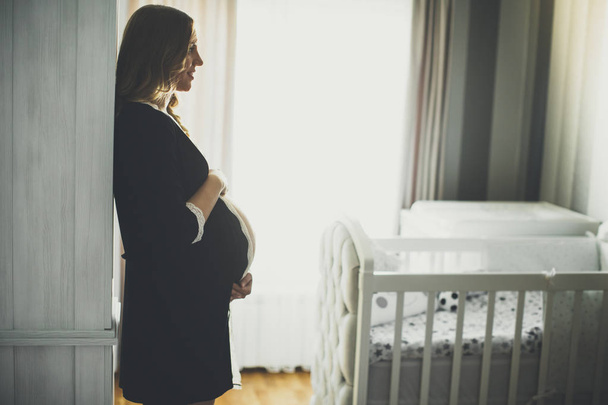 Fiatal terhes nő a hálószobában - Fotó, kép