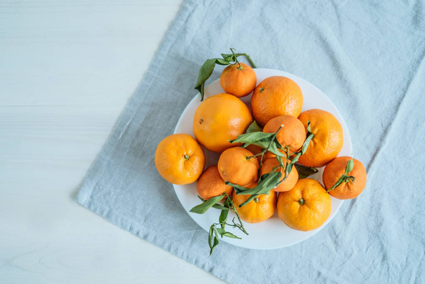 Ripe tangerines in plate  - Foto, afbeelding