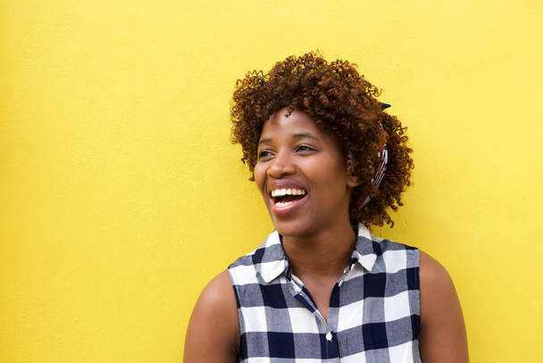 nainen nauraa keltaista seinää vasten
 - Valokuva, kuva