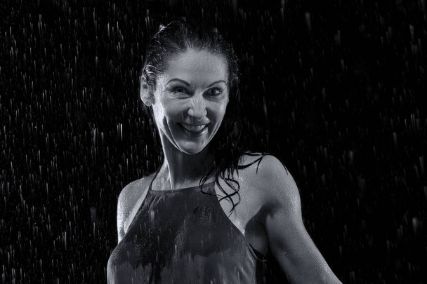 Beautiful woman in rain at night getting wet artistic conversion - Photo, image