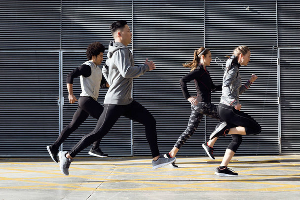 Portrait of group of friends running in the city. - Valokuva, kuva