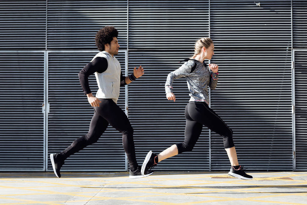 Fit and sporty couple running in the street. - Foto, Imagem