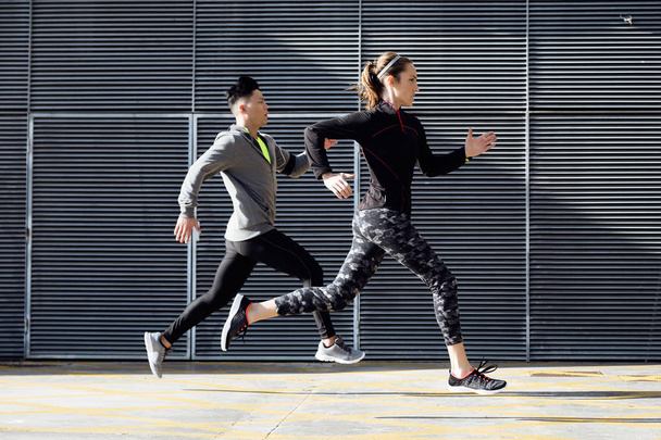 Fit and sporty couple running in the street. - Foto, Bild