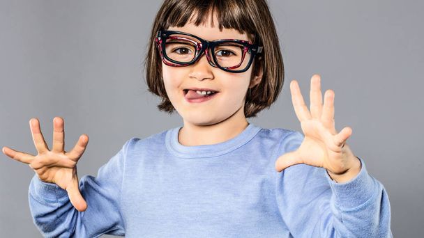 joyful young child wearing many eyeglasses playing, making funny face - Photo, Image