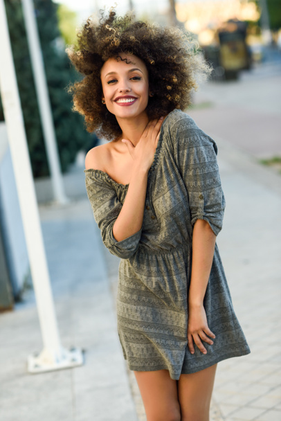 junge schwarze Frau mit Afro-Frisur lächelt im urbanen Hintergrund - Foto, Bild