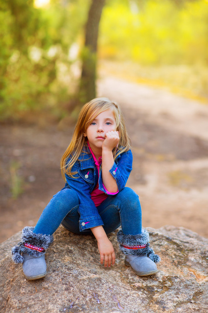 blond kid girl pensive bored in the forest outdoor - Foto, imagen