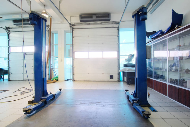 Ascensor en una estación de reparación de automóviles vacía
 - Foto, imagen